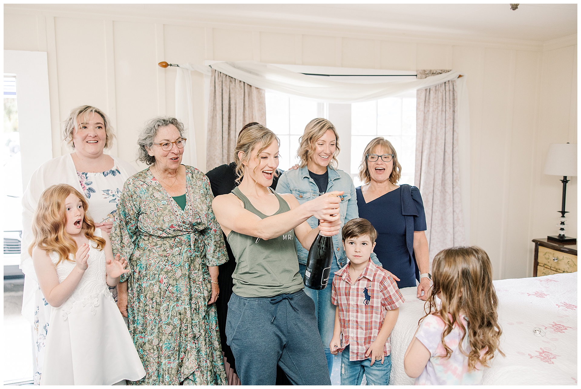 Bride popping the champagne with her family while getting ready.