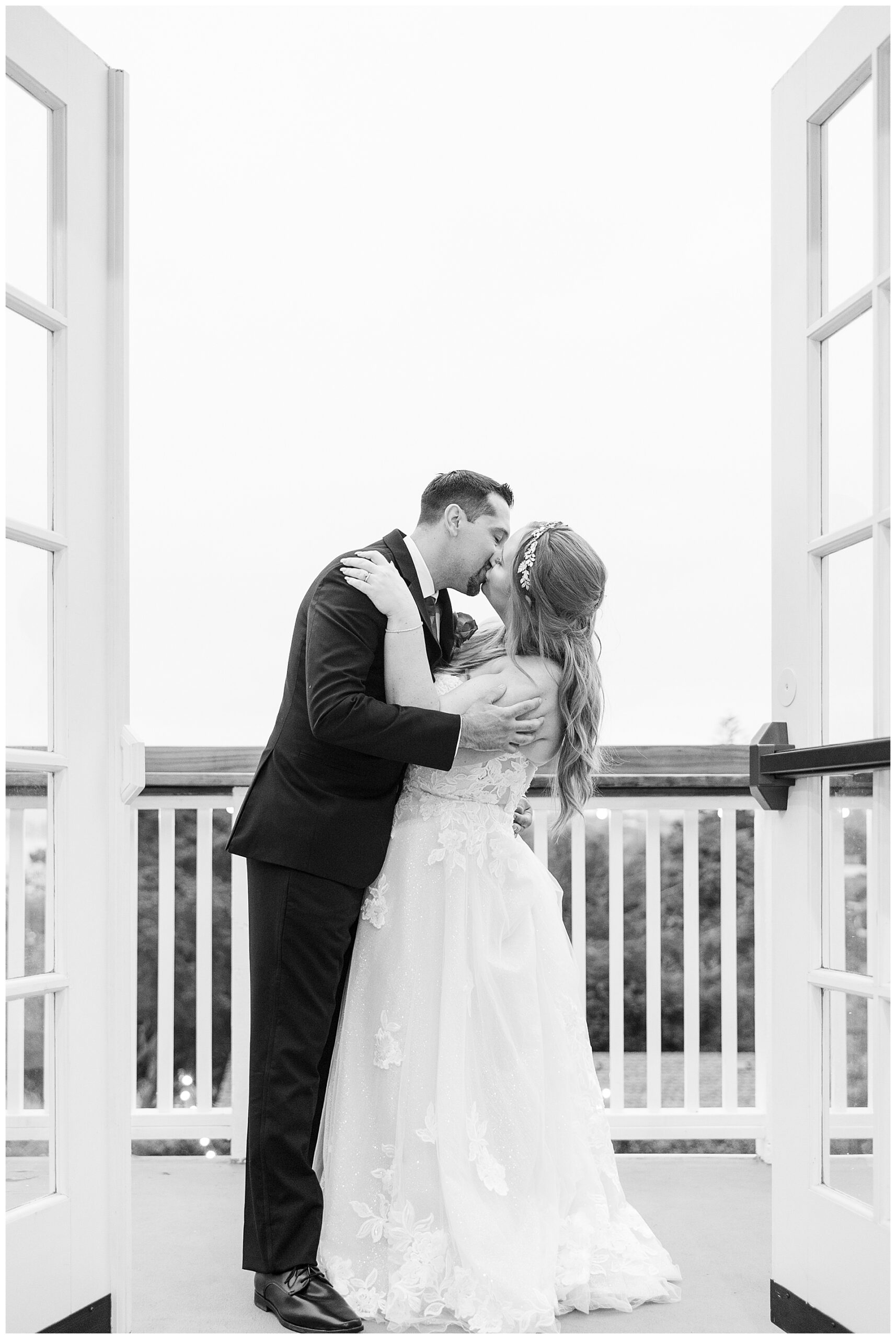 The bride and groom sharing a kiss on the top floor balcony at The Perry House, during their Monterey Wedding.