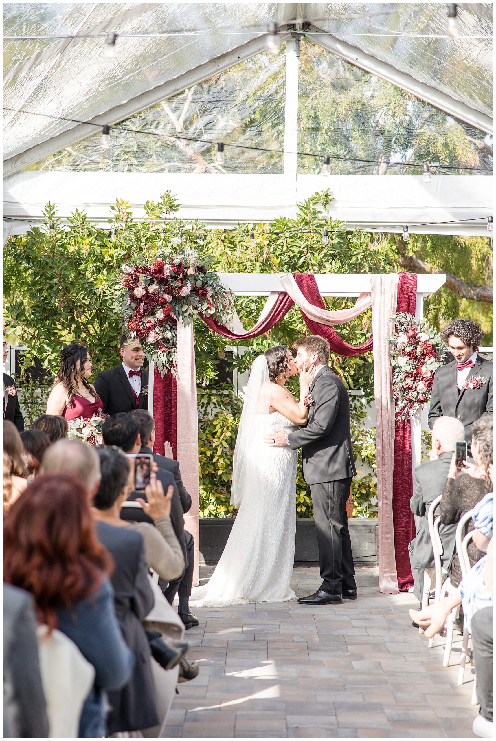 Tent covered ceremony at the Perry House. Bride and groom kiss under the tent.