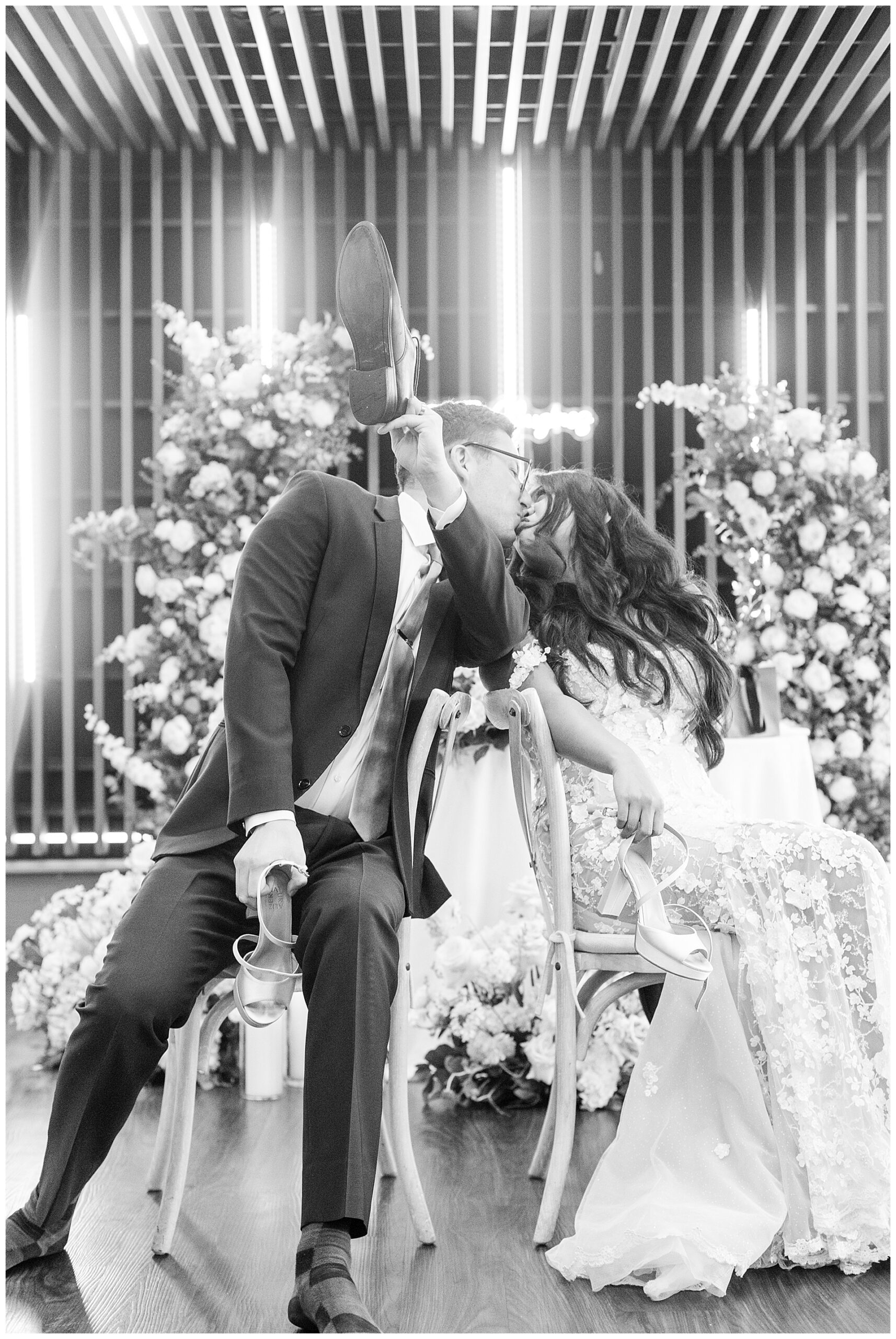 Bride and groom share a kiss while they finish their shoe game at Leguna Seca. 